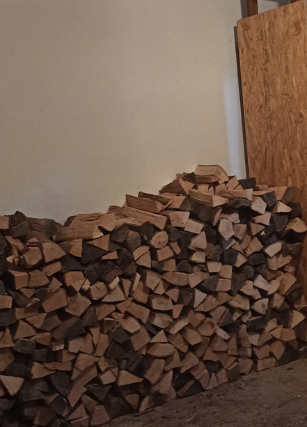 Ein Stapel mit aufgeschichteten Holzscheiten für Brennholz.